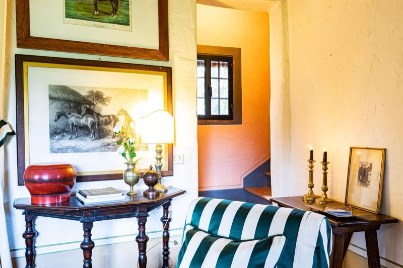 The console with the horse print and candles