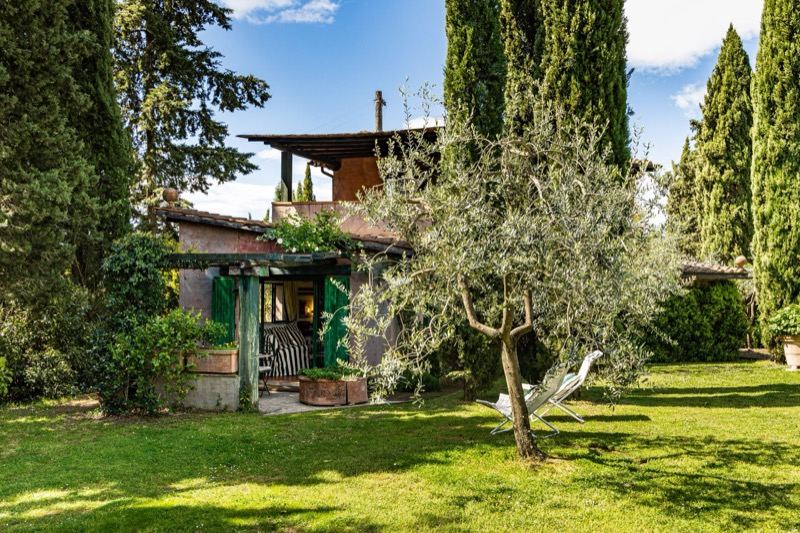 The villa among cypresses and olives, with the lawn