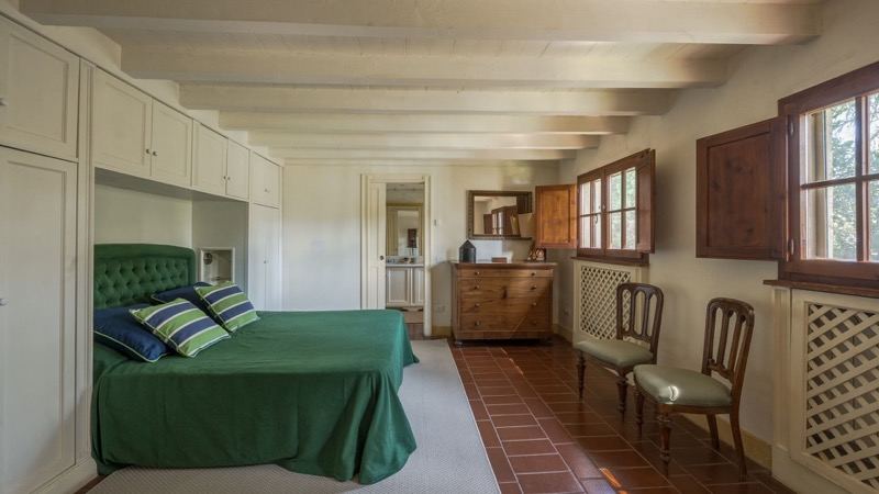 Bedroom with green bedspread and white wardrobes