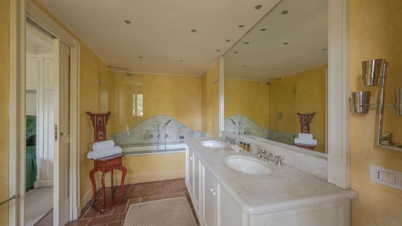 The yellow bathroom with bathtub and double basin