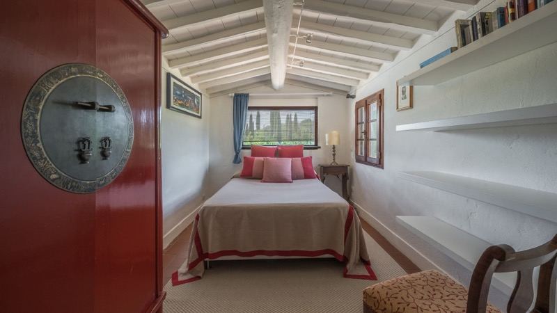 Bedroom with the red door and window onto the cypresses