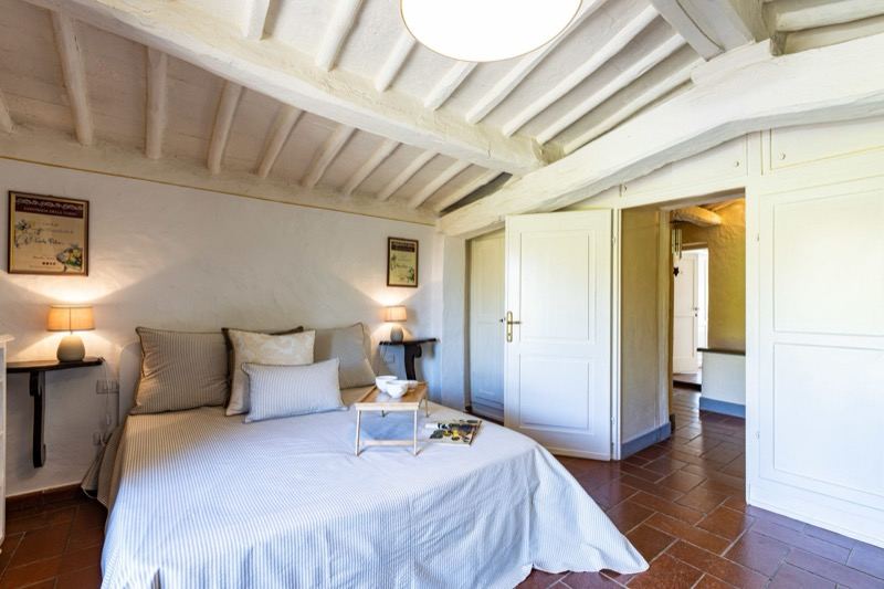 Bedroom under white beams with the double bed