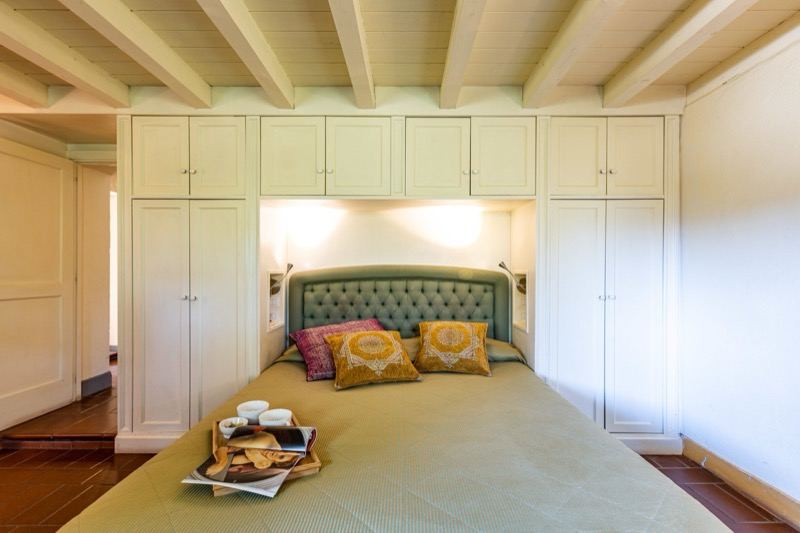 Bedroom with green headboard and built-in wardrobes