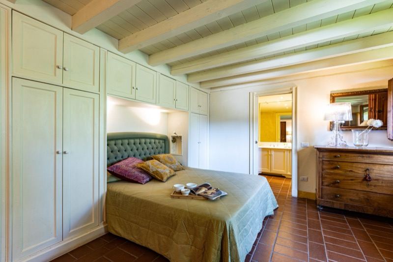 Bedroom with green headboard seen from the doorway
