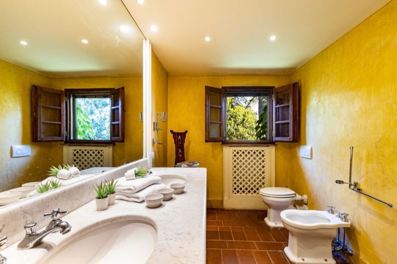 The yellow bathroom with marble basin and windows