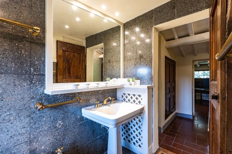 The stone bathroom with mirror and wooden door