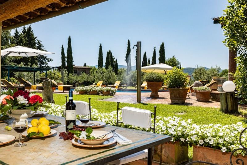 Wine and lemons on the table, the pool behind