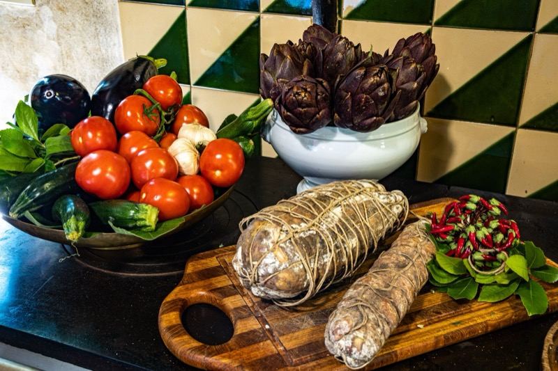 Garden vegetables, artichokes and cured meats on the board