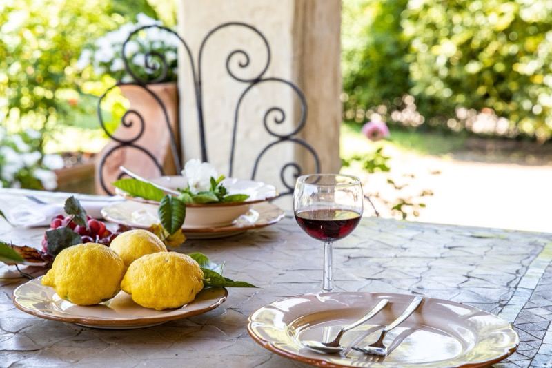 Lemons and a glass of red on the pergola table