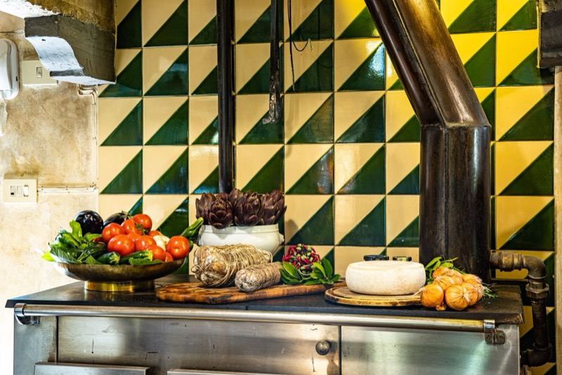 The kitchen with green tiles, vegetables and cheeses