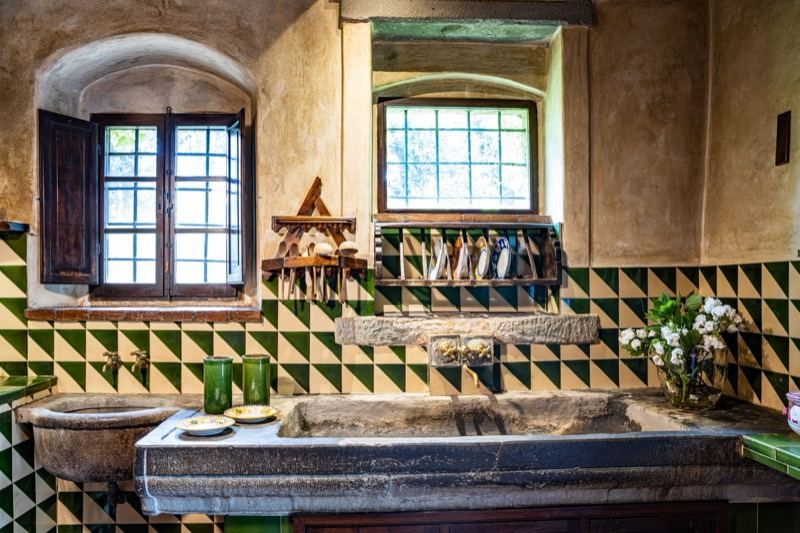 The kitchen with green tiles and the stone sink