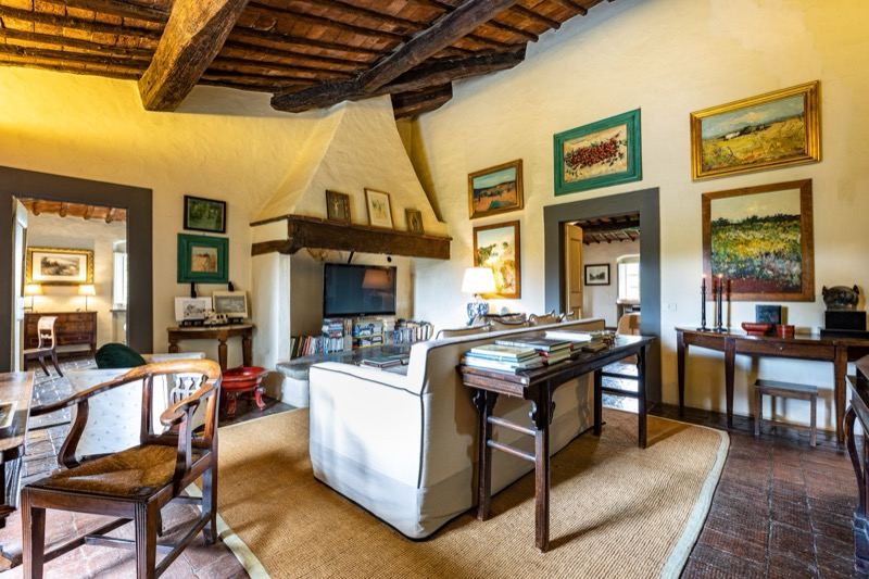 The upstairs living room with the fireplace and paintings