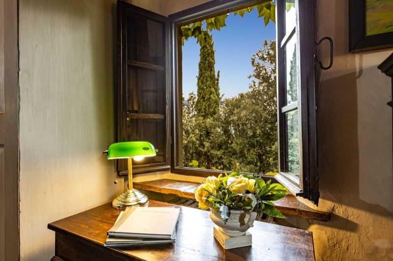 The window open onto the cypresses, with the green lamp