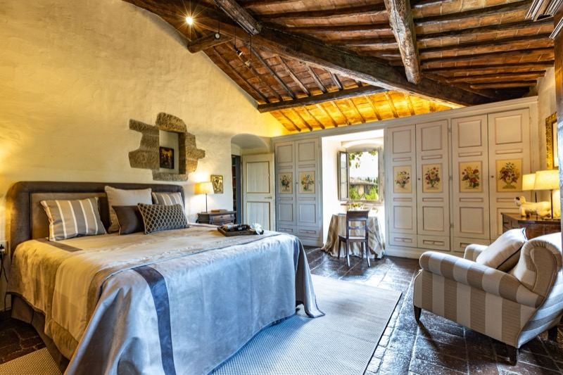 Master bedroom with beams and the striped armchair