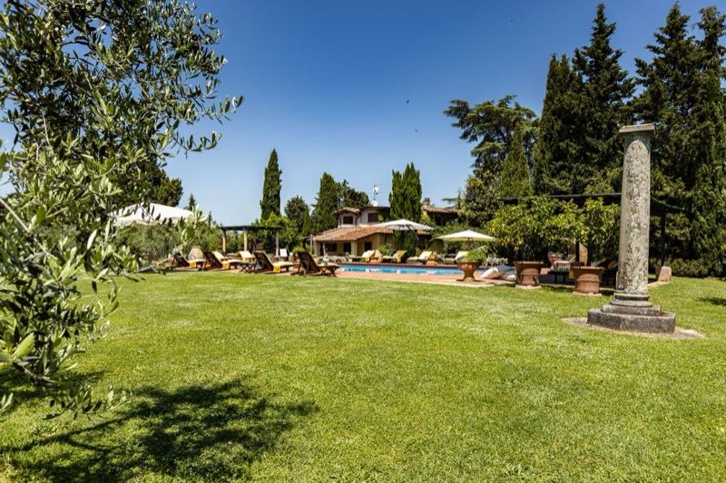 The garden with the stone column and the pool area