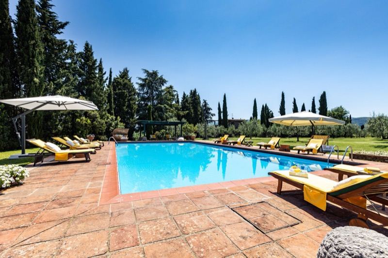 The pool from one end, with parasols and hills