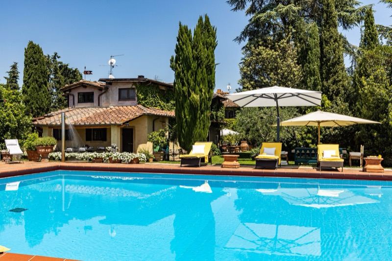 The pool in front of the villa with parasols