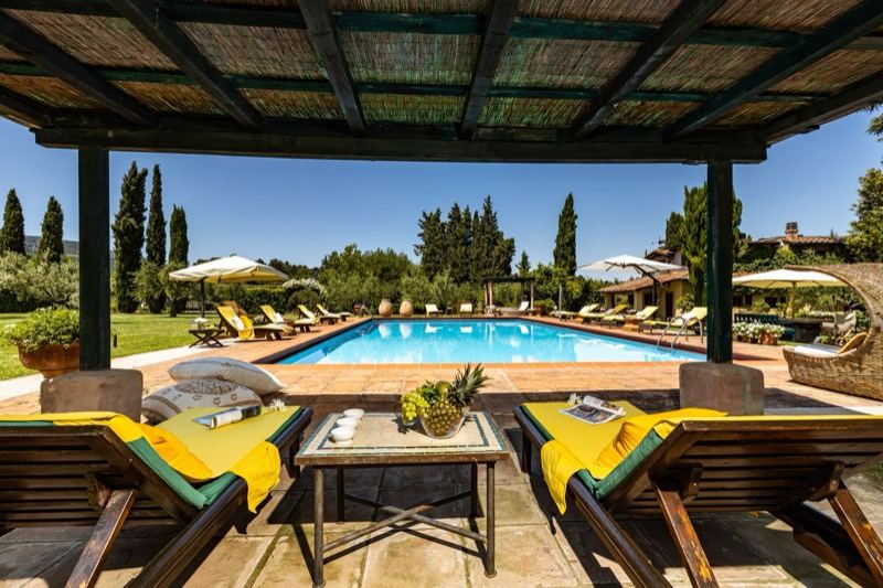 The pergola with loungers and a table overlooking the pool