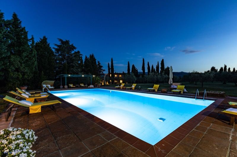 The pool in the evening with cypresses and blue sky