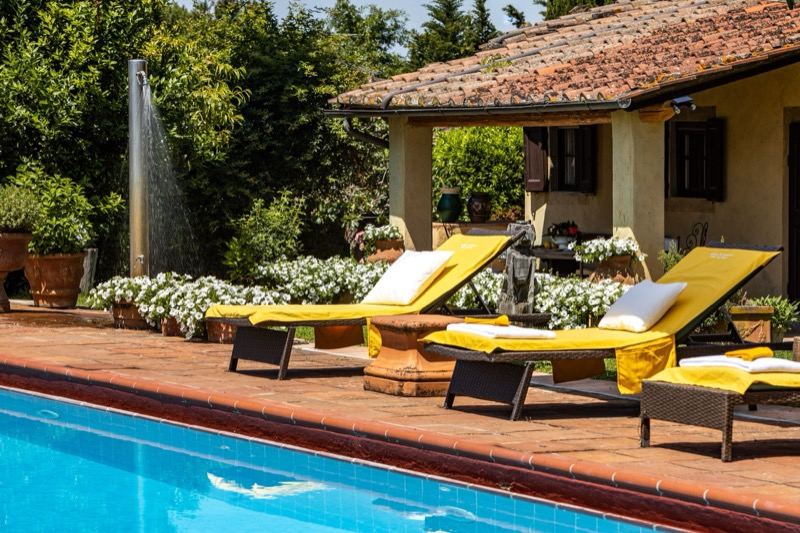 The shower and loungers beside the pool house