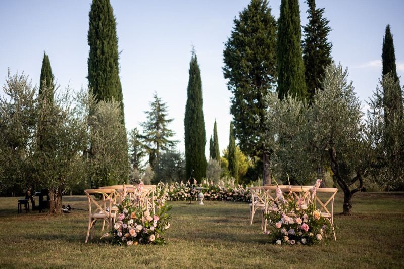 The ceremony chairs among the cypresses with flowers