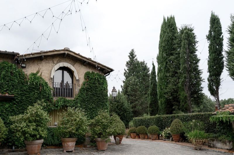 The villa with hanging lights and cypresses
