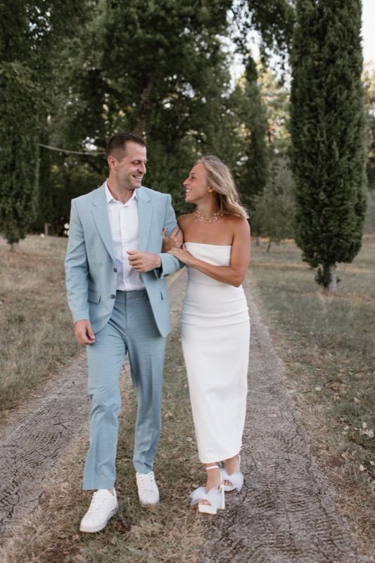 The couple strolling among the cypresses