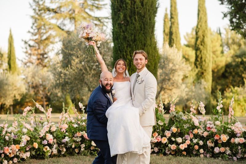 The groom lifting the bride among the altar flowers